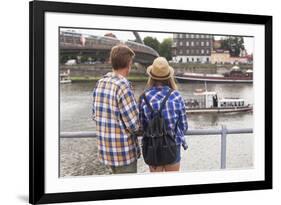 Young Couple on the River Bank in a European City (Rear View) Romantic Journey.-De Visu-Framed Photographic Print