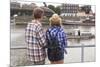 Young Couple on the River Bank in a European City (Rear View) Romantic Journey.-De Visu-Mounted Photographic Print