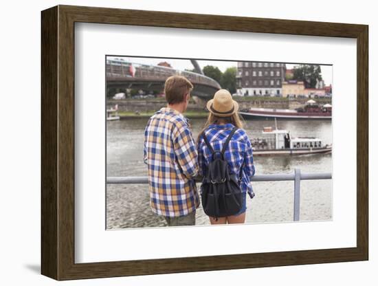 Young Couple on the River Bank in a European City (Rear View) Romantic Journey.-De Visu-Framed Photographic Print