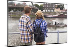 Young Couple on the River Bank in a European City (Rear View) Romantic Journey.-De Visu-Mounted Photographic Print