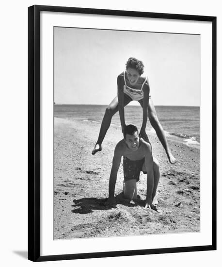 Young Couple Playing Leapfrog on the Beach-The Chelsea Collection-Framed Giclee Print