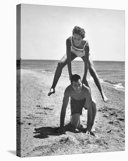 Young Couple Playing Leapfrog on the Beach-The Chelsea Collection-Stretched Canvas