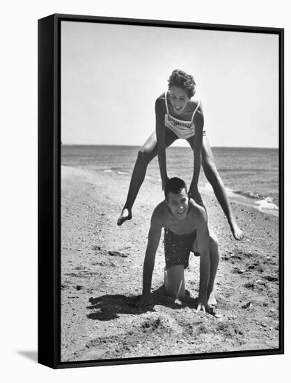 Young Couple Playing Leapfrog on the Beach-The Chelsea Collection-Framed Stretched Canvas