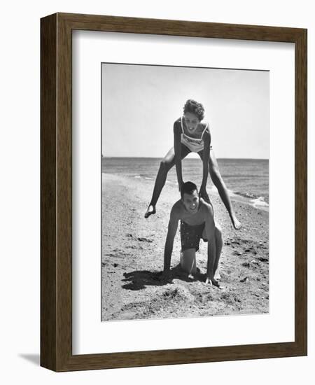 Young Couple Playing Leapfrog on the Beach-The Chelsea Collection-Framed Art Print