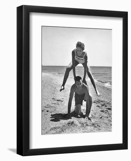 Young Couple Playing Leapfrog on the Beach-The Chelsea Collection-Framed Art Print