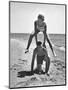 Young Couple Playing Leapfrog on the Beach-The Chelsea Collection-Mounted Art Print