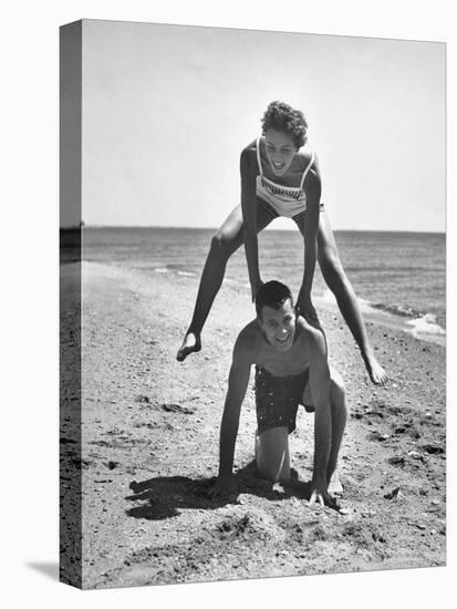Young Couple Playing Leapfrog on the Beach-The Chelsea Collection-Stretched Canvas