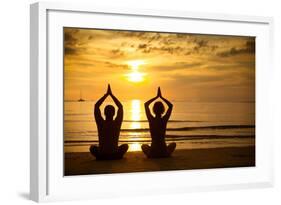 Young Couple Practicing Yoga On The Sea Beach At Sunset-De Visu-Framed Art Print