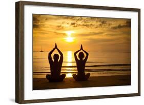 Young Couple Practicing Yoga On The Sea Beach At Sunset-De Visu-Framed Art Print