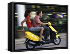 Young Couple Riding on a Motor Scooter-null-Framed Stretched Canvas