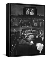 Young Couple Snuggling in Convertible as They Watch Large Screen Action at a Drive-In Movie Theater-J^ R^ Eyerman-Framed Stretched Canvas