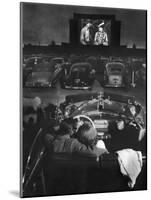 Young Couple Snuggling in Convertible as They Watch Large Screen Action at a Drive-In Movie Theater-J^ R^ Eyerman-Mounted Premium Photographic Print
