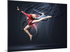 Young Cute Woman In Gymnast Suit Show Athletic Skill On Black Background-Sergey Nivens-Mounted Art Print