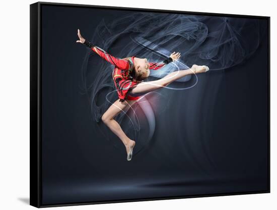 Young Cute Woman In Gymnast Suit Show Athletic Skill On Black Background-Sergey Nivens-Framed Stretched Canvas