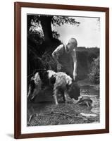 Young Farm Boy Watching His Dog Sniff a Large Turtle at the Pond-Myron Davis-Framed Photographic Print