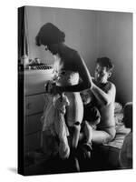 Young Father Helping His Wife Get Dressed as Their Sons Look On-Mark Kauffman-Stretched Canvas