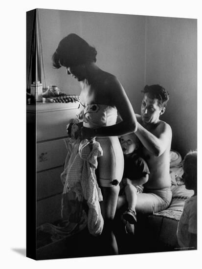 Young Father Helping His Wife Get Dressed as Their Sons Look On-Mark Kauffman-Stretched Canvas