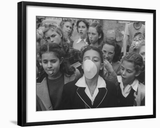 Young Girl Blowing a Bubble with Her Friends Watching-Bob Landry-Framed Photographic Print