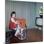 Young Girl Rides Her New Tricycle in the House, Ca. 1967-null-Mounted Photographic Print