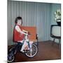 Young Girl Rides Her New Tricycle in the House, Ca. 1967-null-Mounted Photographic Print