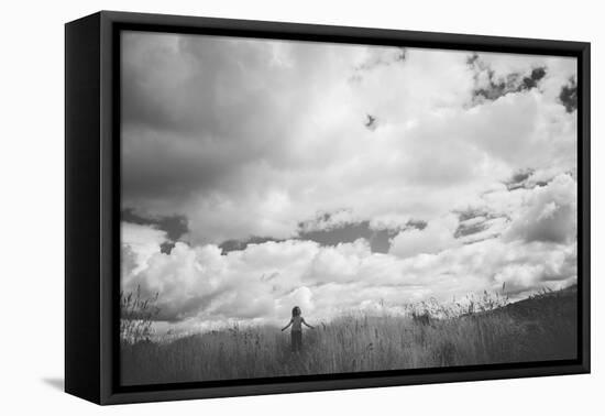 Young Girl Standing in a Field with Clouds-Clive Nolan-Framed Stretched Canvas