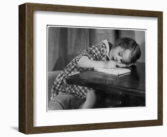 Young Girl Writes on Paper with a Pencil-null-Framed Art Print