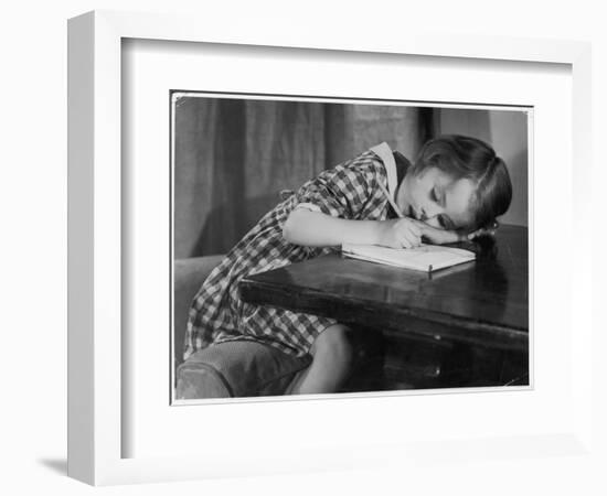 Young Girl Writes on Paper with a Pencil-null-Framed Art Print