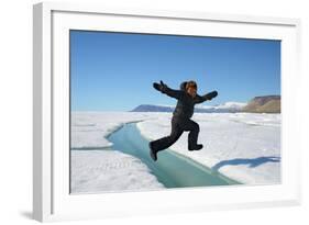 Young Inuit Boy Jumping over a Crack on Ice Floe, Ellesmere Island, Nanavut, Canada, June 2012-Eric Baccega-Framed Photographic Print