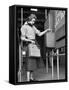 Young Lady Modeling New Line of Clothing While Getting Her Time Card Punched-Yale Joel-Framed Stretched Canvas