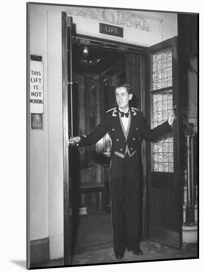 Young Man Blocking the Entrance to the "Lift", in America it Is Called an Elevator-null-Mounted Photographic Print