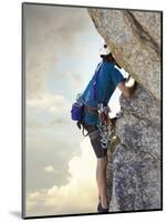 Young man rock climbing up a vertical cliff-null-Mounted Photographic Print