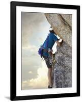 Young man rock climbing up a vertical cliff-null-Framed Photographic Print