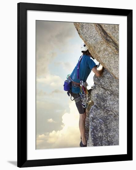 Young man rock climbing up a vertical cliff-null-Framed Photographic Print