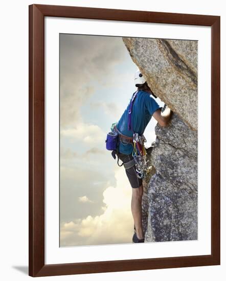 Young man rock climbing up a vertical cliff-null-Framed Photographic Print