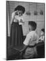 Young School Teacher Explaining to a Little Chinese Boy the Writings on Card That She Is Holding-null-Mounted Photographic Print