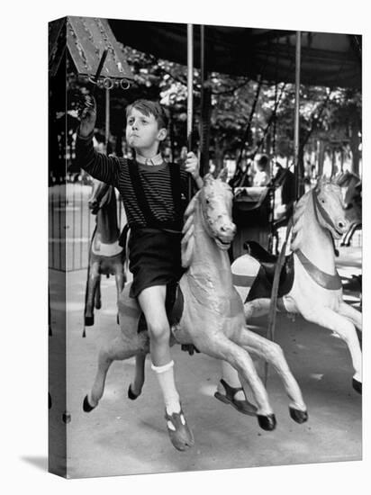 Young Turkish Prodigy Hassan Kaptan Riding a Merry Go Round-Gordon Parks-Stretched Canvas