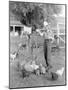 Young Woman Dressed as a Farmer Bringing Food to the Chicken-null-Mounted Photo