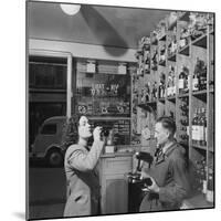 Young Woman Drinking a Bottle of Coca Cola in a Shop, Paris, France, 1950-Mark Kauffman-Mounted Photographic Print