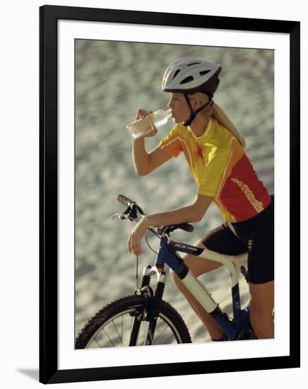 Young Woman Drinking Water While Sitting on a Bicycle-null-Framed Photographic Print