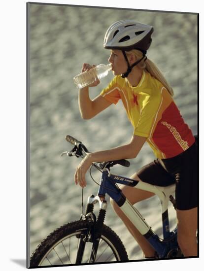 Young Woman Drinking Water While Sitting on a Bicycle-null-Mounted Photographic Print