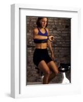 Young Woman Exercising on a Stationary Bike Checking her Heart Rate-null-Framed Photographic Print