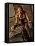 Young Woman Exercising on a Stationary Bike-null-Framed Stretched Canvas