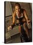 Young Woman Exercising on a Stationary Bike-null-Stretched Canvas