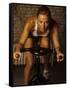 Young Woman Exercising on a Stationary Bike-null-Framed Stretched Canvas