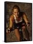 Young Woman Exercising on a Stationary Bike-null-Framed Stretched Canvas