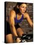 Young Woman Exercising on a Stationary Bike-null-Stretched Canvas