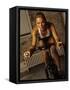 Young Woman Exercising on a Stationary Bike-null-Framed Stretched Canvas