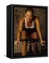 Young Woman Exercising on a Stationary Bike-null-Framed Stretched Canvas