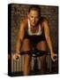 Young Woman Exercising on a Stationary Bike-null-Stretched Canvas