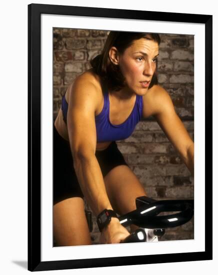 Young Woman Exercising on a Stationary Bike-null-Framed Photographic Print